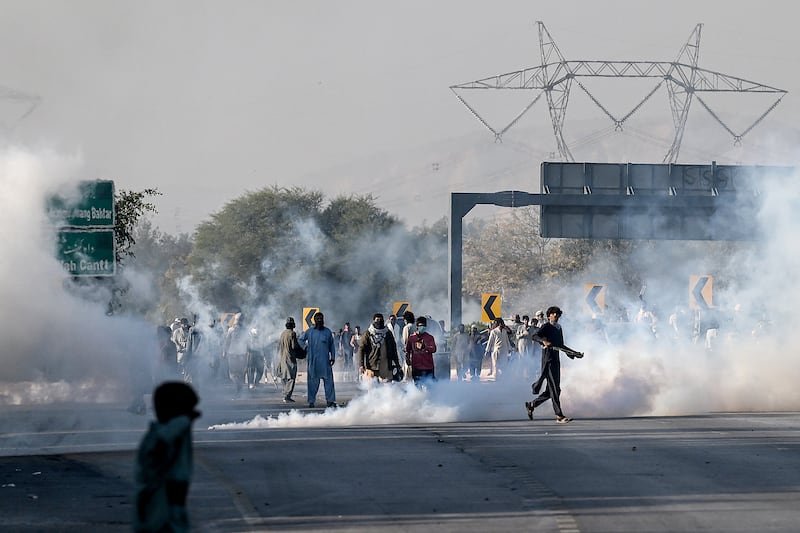 Members of Khan's party attempt to throw teargas shells fired by riot policemen back as they protest during a march to Islamabad demanding Khan's release on November 25th. Photograph: Aamir Qureshi/AFP via Getty