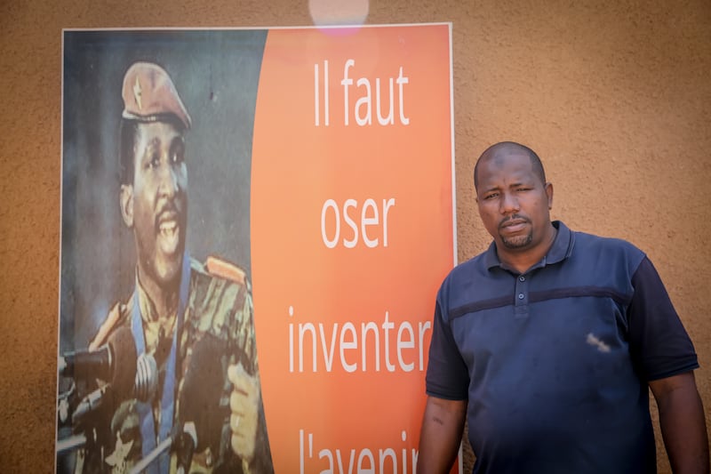 Abdoulaye Seydou stands beside a picture of Thomas Sankara, who he described as one of his idols. Photograph: Sally Hayden.