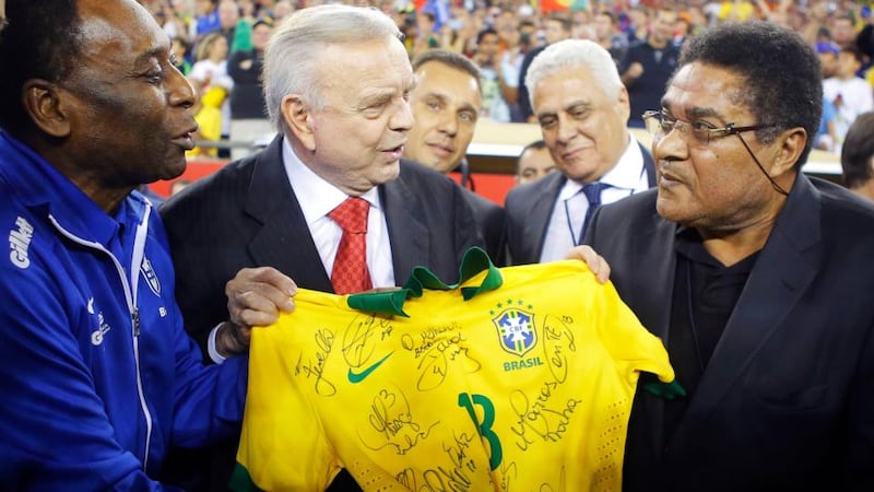 Soccer greats Pele (left) of Brazil and Eusebio (right) of Portugal hold a signed Brazil jersey in front of president of Brazil’s soccer federation Jose Maria Marin before an international friendly match between Brazil and Portugal in September 2013. Photograph: Reuters