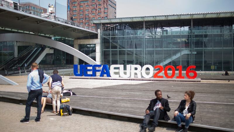 Pedestrians sit near an UEFA Euro 2016 sign in Lille, France. Photograph: EPA/Shawn Thew