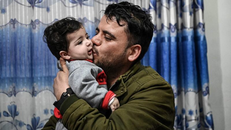 Hamid Safi, a taxi driver who found Sohail Ahmadi on the ground at Kabul airport and tracked down the family, kisses Sohail, who was separated from his parents at the airport in the chaos of the US evacuation of Afghanistan in August 2021, at Sohail’s grandfather’s house in Kabul on January 9, 2022. Photograph: Mohd RAasfan/ AFP via Getty Images