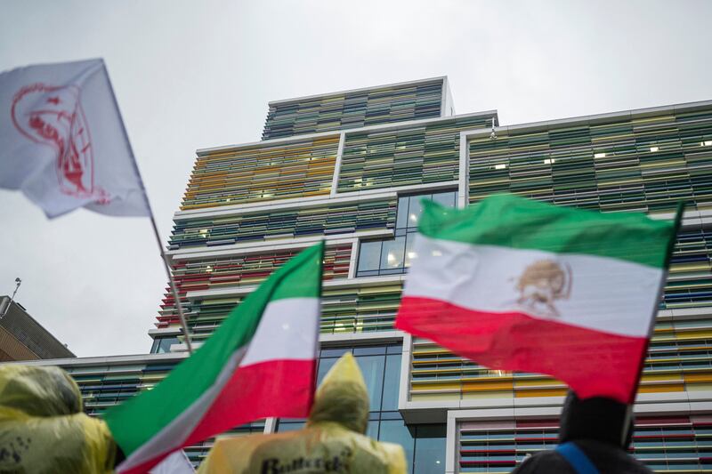 Protesters wave a historic Iranian flag with the Lion and Sun symbol as they gather outside the appeals court building in Stockholm, Sweden in January 11 at the start of the appeal trial of Hamid Noury. Photograph: Jonathan Nackstrand/AFP via Getty Images