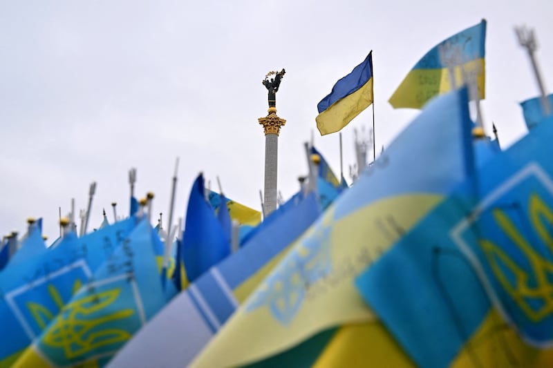 The landmark Independence Monument is seen through the national flags of Ukraine, each dedicated to a serviceman killed during the Russian invasion of Ukraine, marking the first anniversary of the war in Kyiv. Photograph: Sergei Supinsky/AFP