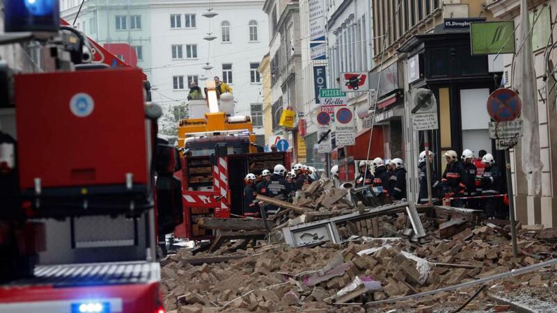 Austrian firefighters stand in front of a partially collapsed building in Vienna this morning. Photograph: Leonhard Foeger/Reuters