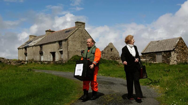 Sgt Val Murray assists Carmel McBride, presiding officer for Inishbofin, off Co Donegal, with the ballot box as Islanders go to the polls a day earlier in the local and European elections. Photograph: Brian Lawless/PA Wire