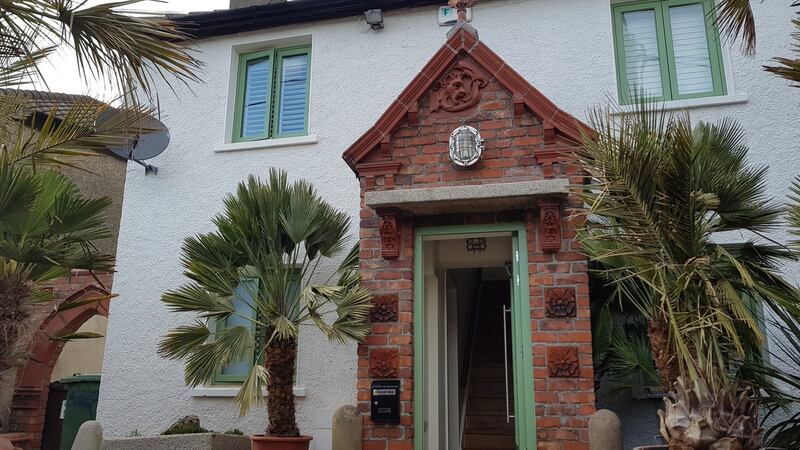 The former council house has a red brick Victorian church porch front, a palm garden and an old post box built into one of its walls.