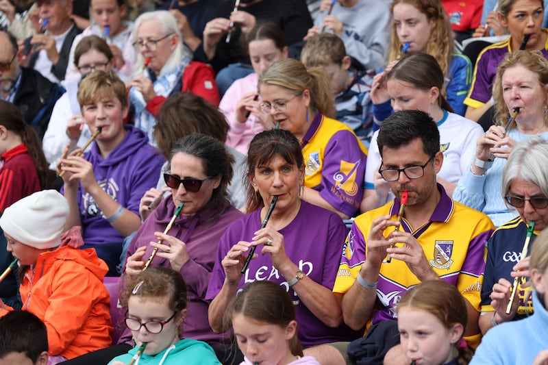 Evelyn Callaghan (centre left, wearing sunglasses) Pauline O'Brien (centre) and Andy Mahoney(centre right) from Wexford are among those who participated in the successful Tin Whistle Guinness World Record attempt for the most tin whistles played continuously for five minutes at Chadwicks Wexford Park during the Comhaltas Fleadh Cheoil na hÉireann.  2,516  tin whistle players performed two songs ‘The Boys of Wexford’ and ‘The Dawning of the Day March’. Photograph: Bryan O’Brien / The Irish Times
