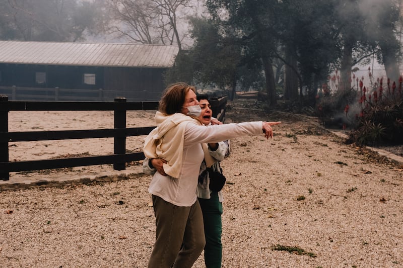 Nancy Chiamulon (left) and a property worker try to contain a fire encroaching on their property during the Palisades Fire. Photograph: Mark Abramson/The New York Times
                      