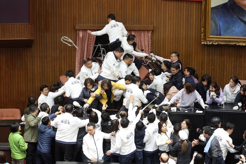 Lawmakers from the main opposition Kuomintang (KMT) (in white) try to break into Parliament where Democratic Progressive Party (DPP) occupied the night to avoid the passing of the third reading of amendments to the Civil Servants Election and Recall Act and other controversial bills at the Legislative Yuan in Taipei. Photograph: I-Hwa Cheng/AFP