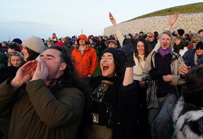 People celebrate the sun rising as they gather at Newgrange. Photograph: Brian Lawless/PA Wire