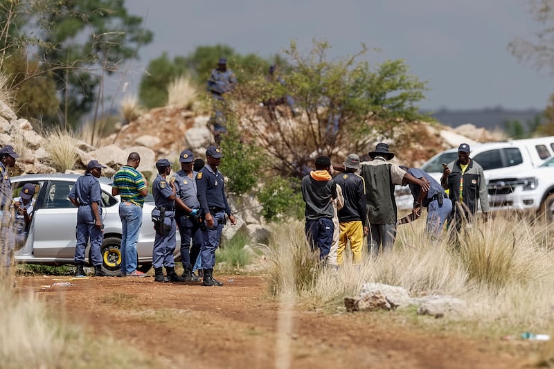 Community members are searched by South African Police Service officers before entering the mine shaft to negotiate with miners underground to resurface in Stilfontein. Photograph: Emmanuel Croset/AFP via Getty Images