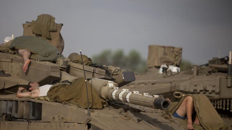 Israeli soldiers sleep on a tank in a deployment area  on Israel’s border with the Gaza Strip. Israel’s Operation Protective Edge entered its sixth day on Sunday, as the death toll in Gaza mounted to more than 160 Palestinians, while the international community stepped up pressures to reach a cease-fire. Photograph: Lior Mizrahi/Getty Images