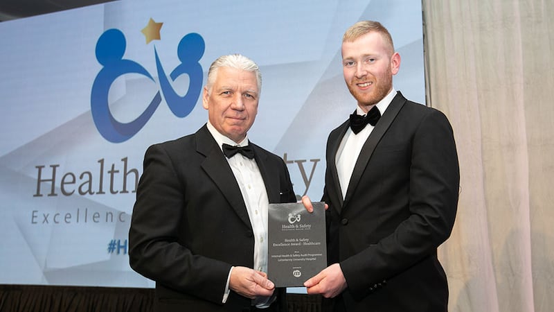 Eric Doyle, managing director at ISS Facility Services Ireland, presents the Health & Safety Excellence Award - Healthcare to Neil Wall, Business River, on behalf of Letterkenny University Hospital