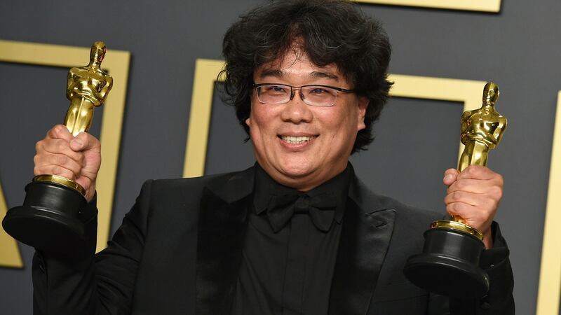 Bong Joon-ho poses with the awards for best director for Parasite and best international feature film for Parasite. Photograph:  Jordan Strauss/Invision/AP