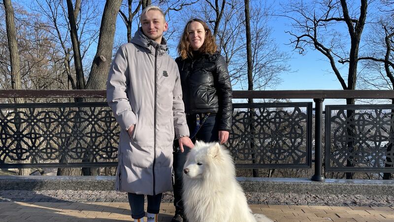 Vlad Lozyn, Olena Hanich and Ace walk in a Kyiv park after a 39-hour curfew ended at 8am on Monday.