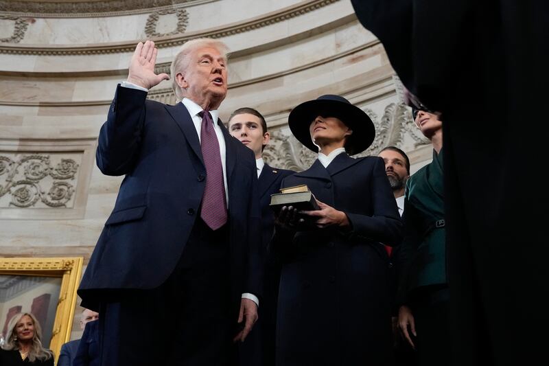 Donald Trump is sworn in as the 47th president of the United States by Chief Justice John Roberts as Melania Trump holds the Bible during the 60th Presidential Inauguration in the Rotunda of the US Capitol in Washington.