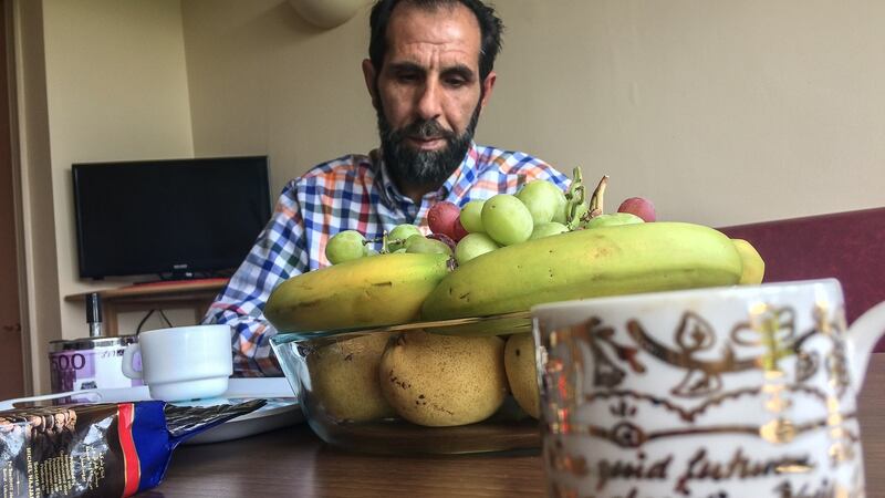 Nazim  gazes at the plate of fruit in front of him, and begins to cry: ‘I want to give a banana to my child’. Photograph: Sally Hayden