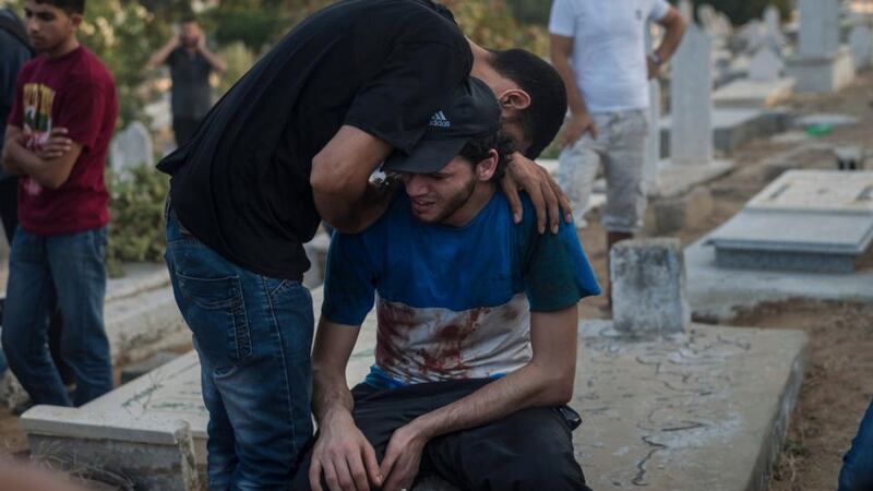 Palestinian men cry after the funerals of children, who were reportedly killed during an explosion at a park in the Shati refugee camp in Gaza City yesterday. Photograph: Sergey Ponomarev/The New York Times