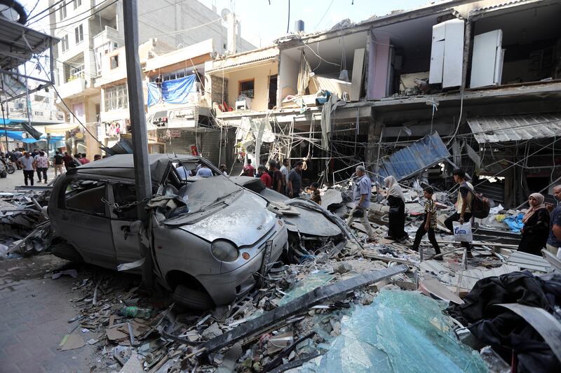 Residents walk past the wreckage of the Al-Majaida family’s home after an Israeli airstrike on Thursday in the southern Gaza Strip. Photograph: Yousef Masoud/The New York Times                      