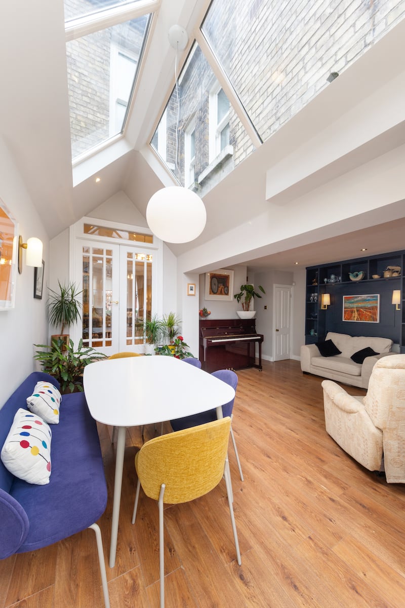 The dining area is bright thanks to a large overhead roof light