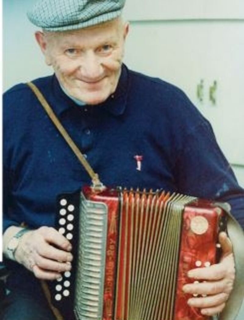 Man wearing a cap, holding an accordion