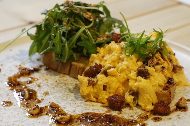 Chorizo eggs: Sourdough toast, house hummus, topped with soft scrambled eggs and chorizo, crushed house roasted peanuts, One Society peanut rayu, sliced spring onion and dressed rocket. Photograph: Nick Bradshaw