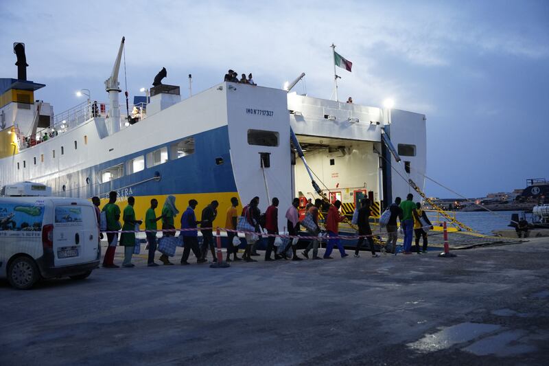 Migrants wait to board a ship to be transported to other cities, on the Italian island of Lampedusa. Photograph: Zakaria Abdelkafi/ AFP