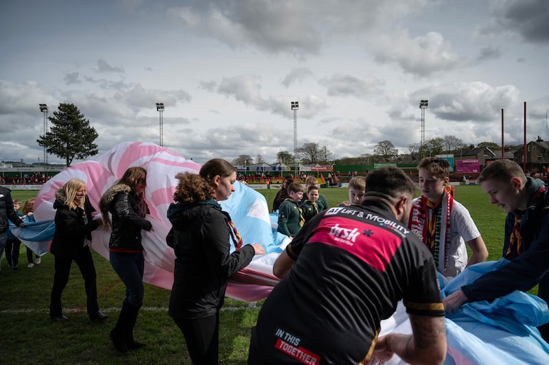 A banner in the blue, pink and white of the trans rights movement unfurled before a rugby match. Photograph: Mary Turner/The New York Times
                      