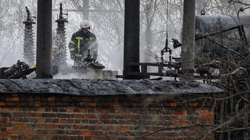 A firefighter surveys the damage at traction substation building near rail lines, which officials said were the target of a Russian missile attack, near Lviv, Ukraine.  Photograph:  Leon Neal/Getty Images