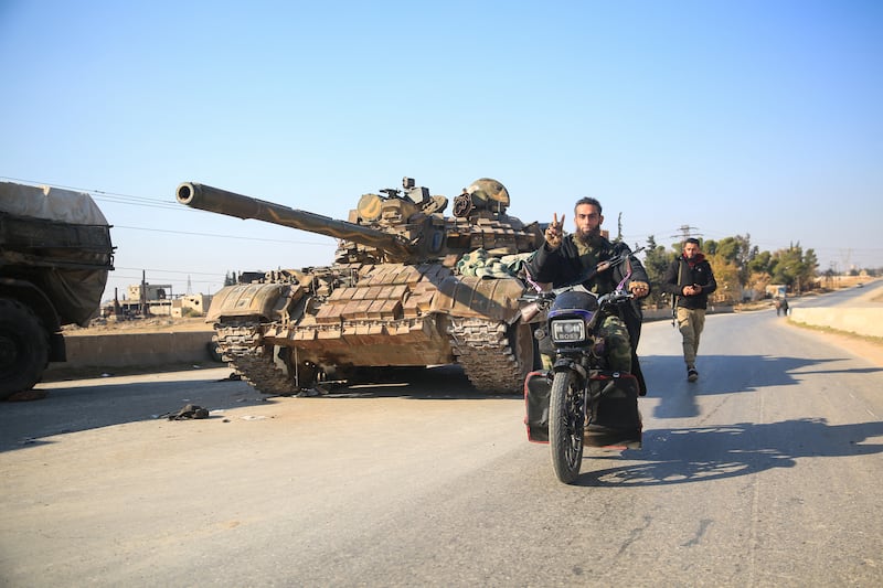 Anti-government fighters pass by abandoned Syrian army equipment near al-Safirah, southeast of Aleppo on December 3rd. Photograph: Aref Tammawi/AFP via Getty