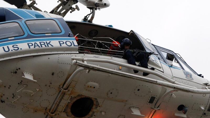 A law enforcement officer with a rifle sits in a helicopter above the scene of a shooting at the Washington Navy Yard in Washington, yesterday. Photograph: Jonathan Ernst/Reuters