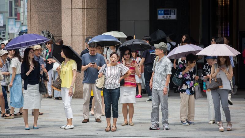 People use parasols to try to escape the heat on Sunday in Ginza, Tokyo.  Photograph: Yuichi Yamazaki/Getty Images