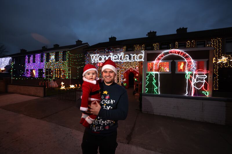 Dylan Walsh and his 8-month-old son Max with the Christmas lights display outside their home and those of his neighbours in Finglas, Dublin, raising money for Willow's Army and Hear Me Out Project. Photograph: Dara Mac Dónaill






