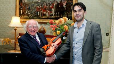 Syrian refugee presents violin he made to Michael D Higgins